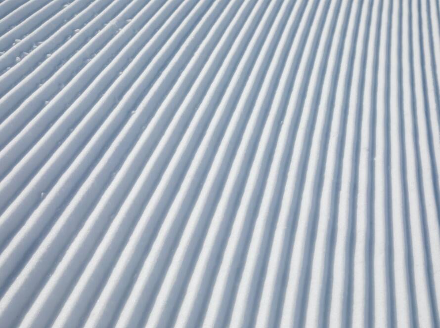 Diagonal track lines on a ski slope left by a snowcat