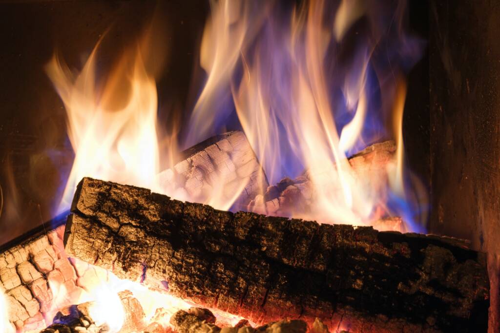 A fireplace with burning logs. Fire in the fireplace. A cozy place to rest.